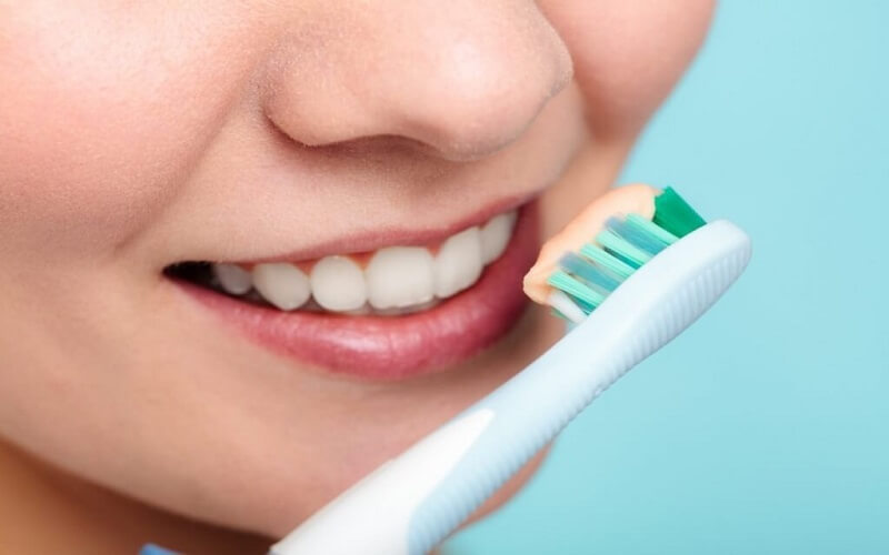 Chăm sóc răng miệng hợp lý để khắc phục răng sứ ố vàng, xỉn màu nhẹ.